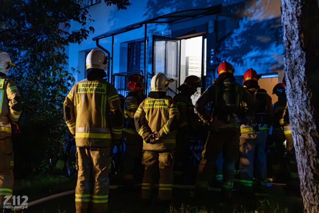 Strażacy przed wejściem do bloku – nocna akcja gaśnicza przy ul. Dzierżona w Zabrzu.