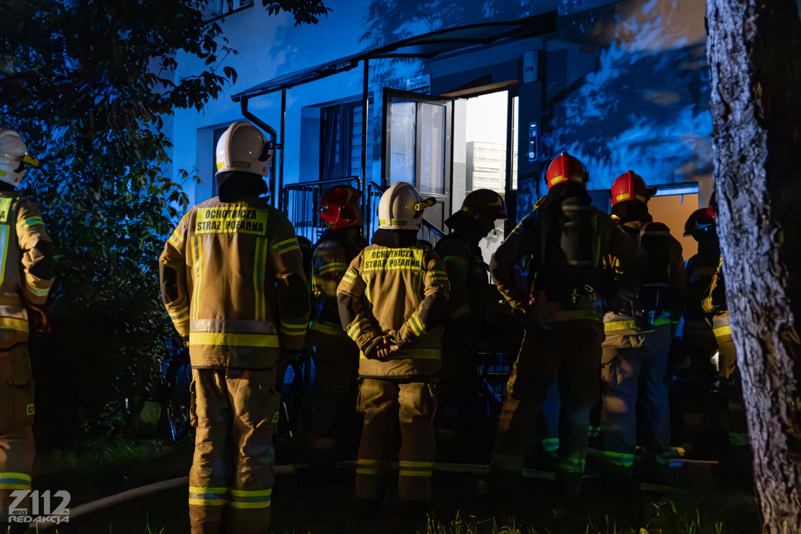 Strażacy przed wejściem do bloku – nocna akcja gaśnicza przy ul. Dzierżona w Zabrzu.